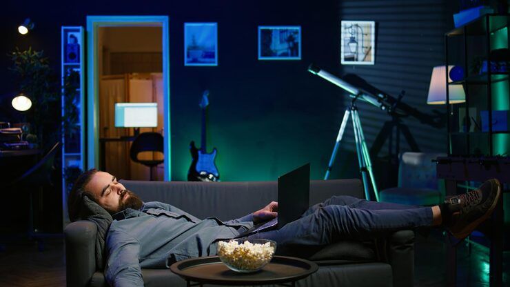 Person relaxing while streaming Gamma IPTV content on multiple devices