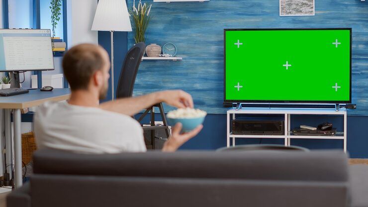 Man enjoying entertainment content on Gamma IPTV while eating popcorn